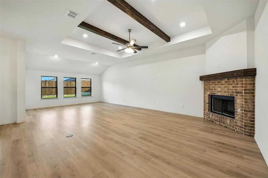 Unfurnished living room featuring a brick fireplace, ceiling fan, light wood-style flooring, and recessed lighting