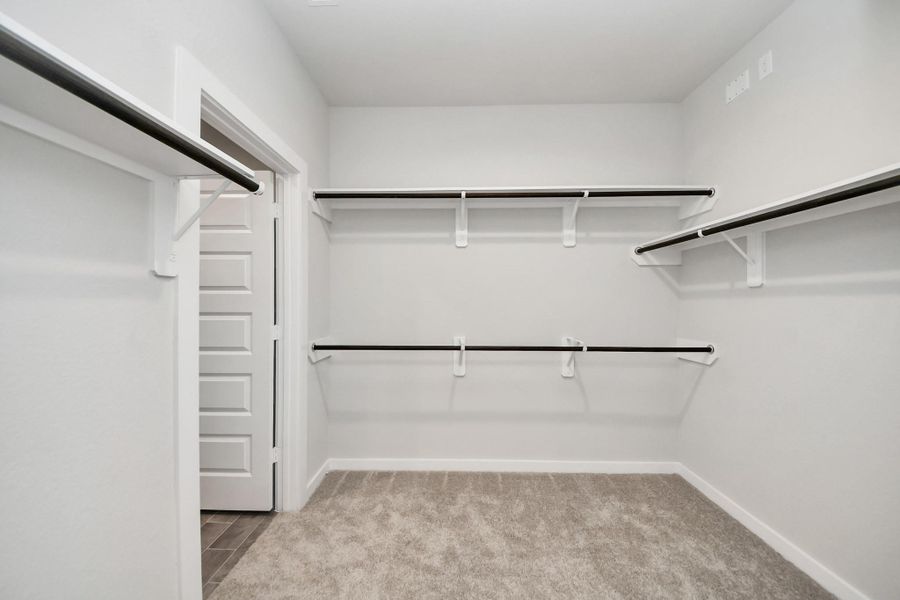Walk-in closet that epitomizes luxury and practicality. This generously sized space features built-in shelving, offering abundant room for impeccable organization. High ceilings and recessed lighting create a bright and welcoming ambiance. Sample photo of completed home with similar floor plan. Actual colors and selections may vary. Walk-in closet that epitomizes luxury and practicality. This generously sized space features built-in shelving, offering abundant room for impeccable organization. High ceilings and recessed lighting create a bright and welcoming ambiance. Sample photo of completed home with similar floor plan. Actual colors and selections may vary.
