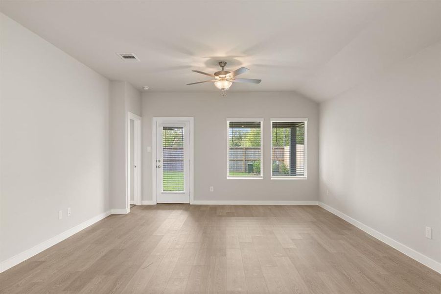 An additional view of the Luxurious Living Room with neutral finishes, ceiling fan for added comfort and access to the Beautiful Backyard.