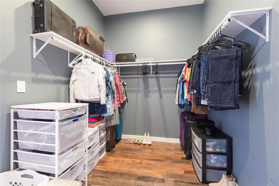 Walk in closet with light wood-style floors Walk in closet with light wood-style floors