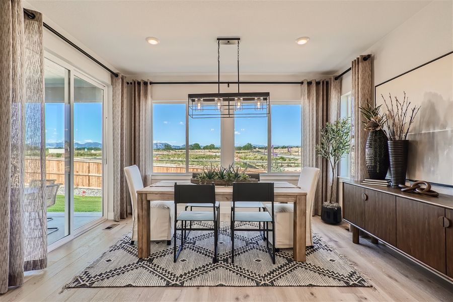 A kitchen and dining room with a large window overlooking a city. A kitchen and dining room with a large window overlooking a city.