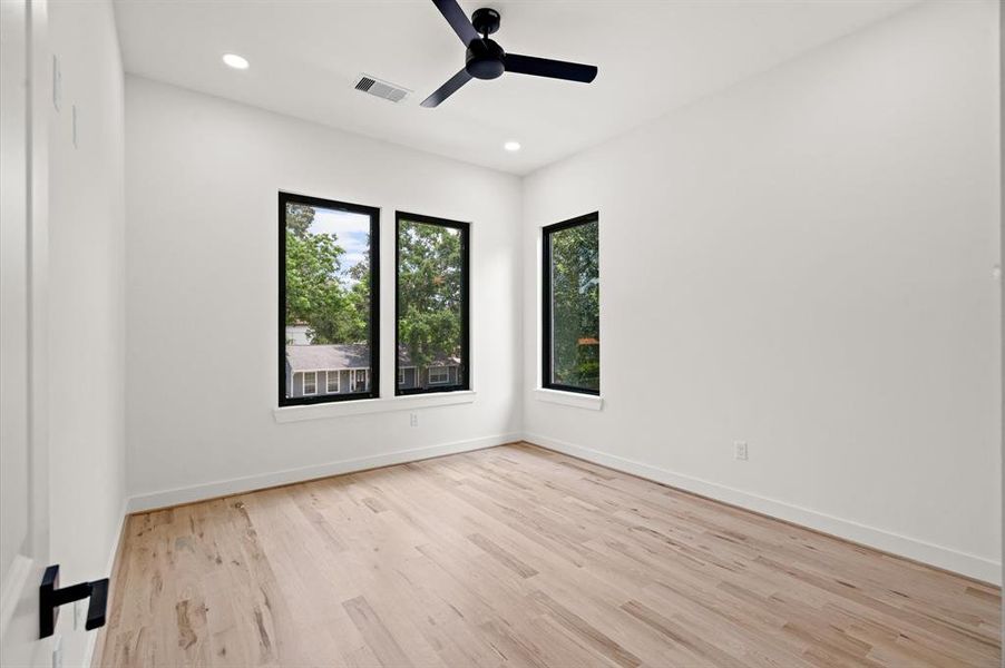 Secondary bedroom, each with recessed LED lighting, fan, and oak floors.