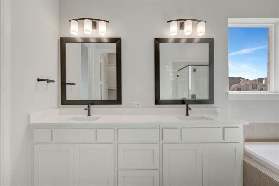 Bathroom with double vanity, a stall shower, and a bath