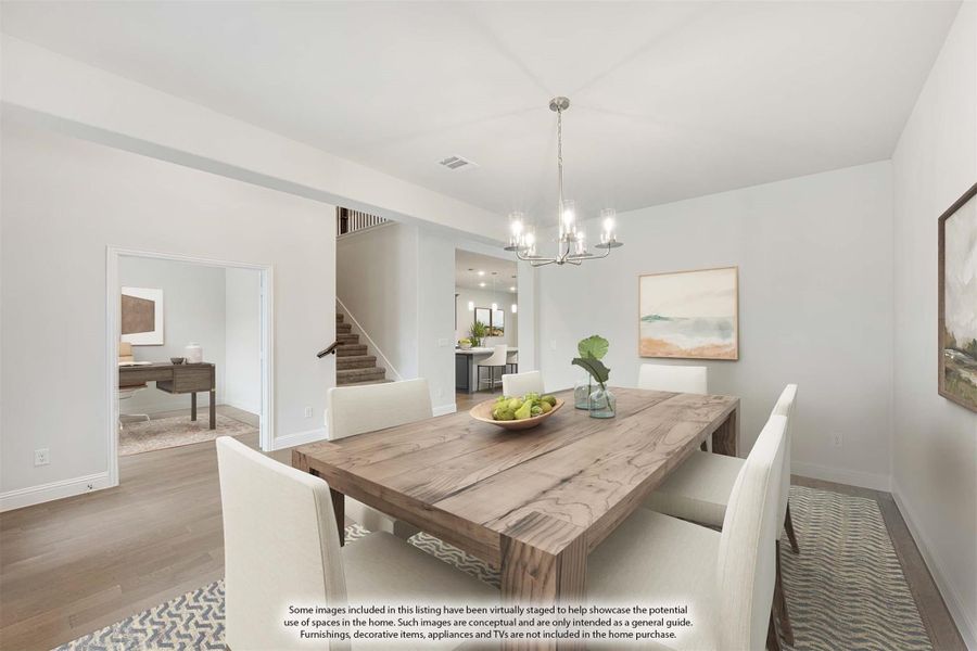 Dining room with wood table, white chairs, chandelier, and hardwood floors open to staircase Dining room with wood table, white chairs, chandelier, and hardwood floors open to staircase
