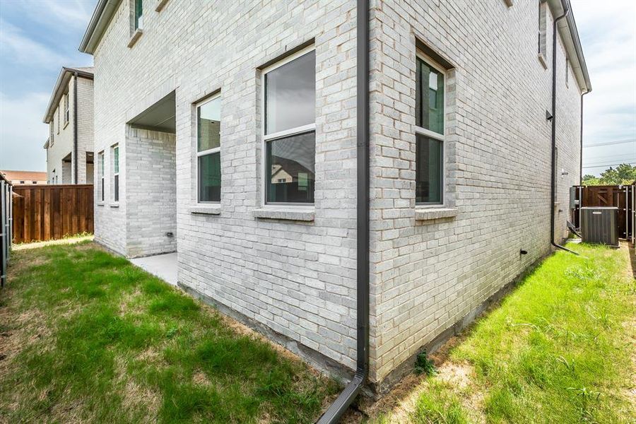 View of side of property featuring a lawn and central air condition unit