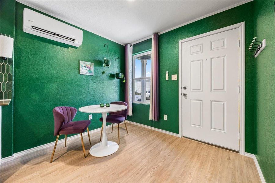 Entryway with a wall mounted mini split, light wood-style floors, and a textured wall Entryway with a wall mounted mini split, light wood-style floors, and a textured wall