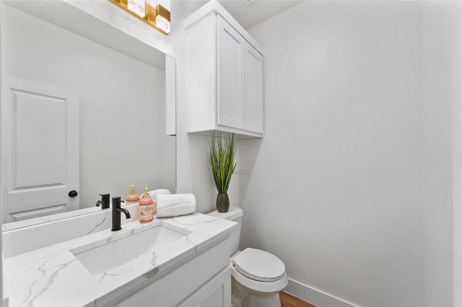 White vanity with a rectangular undermount sink, a white countertop with grey veining, and a matte black faucet White vanity with a rectangular undermount sink, a white countertop with grey veining, and a matte black faucet