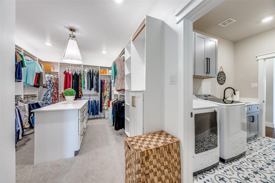 Spacious closet featuring washing machine and clothes dryer and light colored carpet