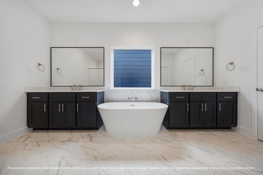 Indulge in daily elegance as you're greeted by the cheerful symmetry of fixtures in your luxuriously styled primary bathroom.