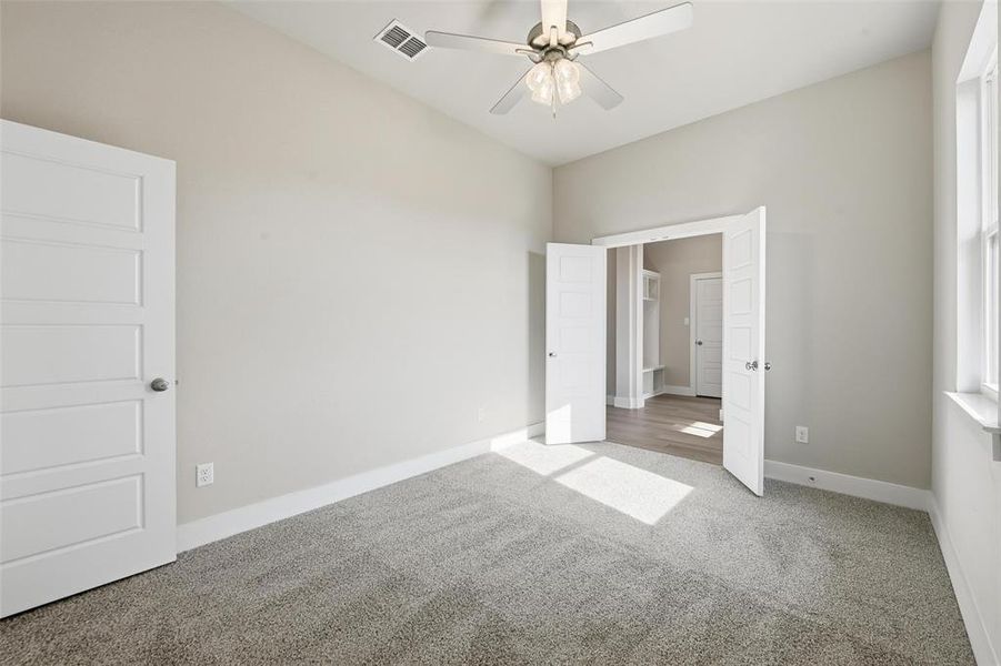 Unfurnished bedroom with carpet flooring and ceiling fan