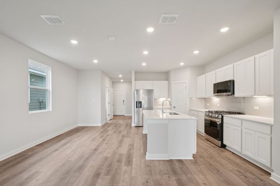 A kitchen with white cabinets.