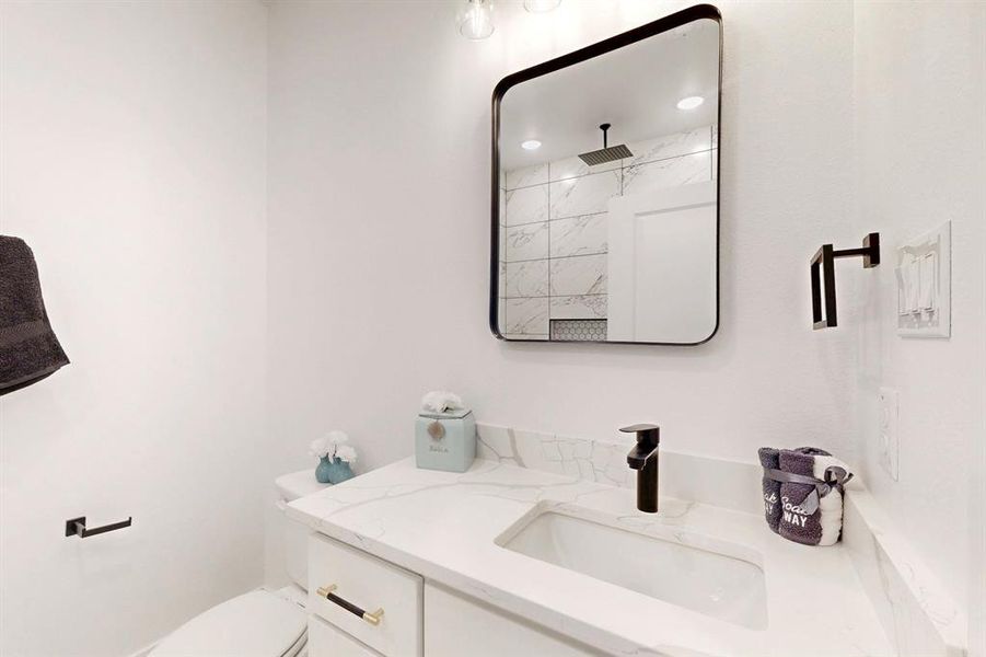 Bathroom featuring toilet, vanity, and walk in shower