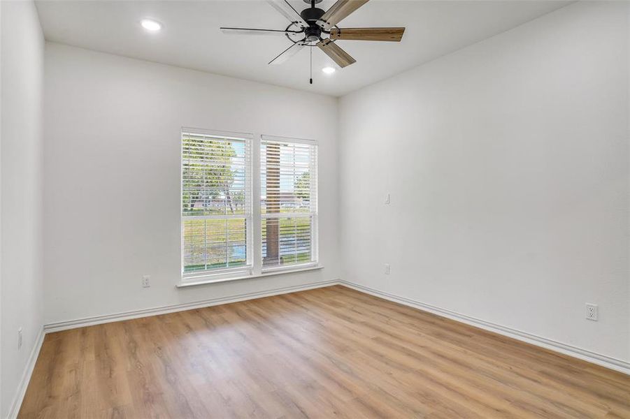 Unfurnished room with ceiling fan and light wood-type flooring