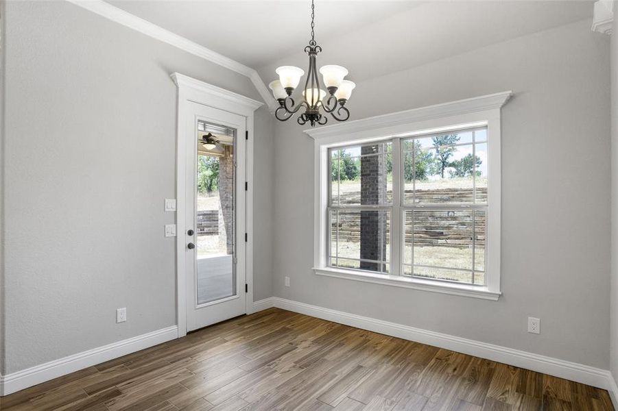 Doorway to outside featuring hardwood / wood-style flooring, a chandelier, and a healthy amount of sunlight