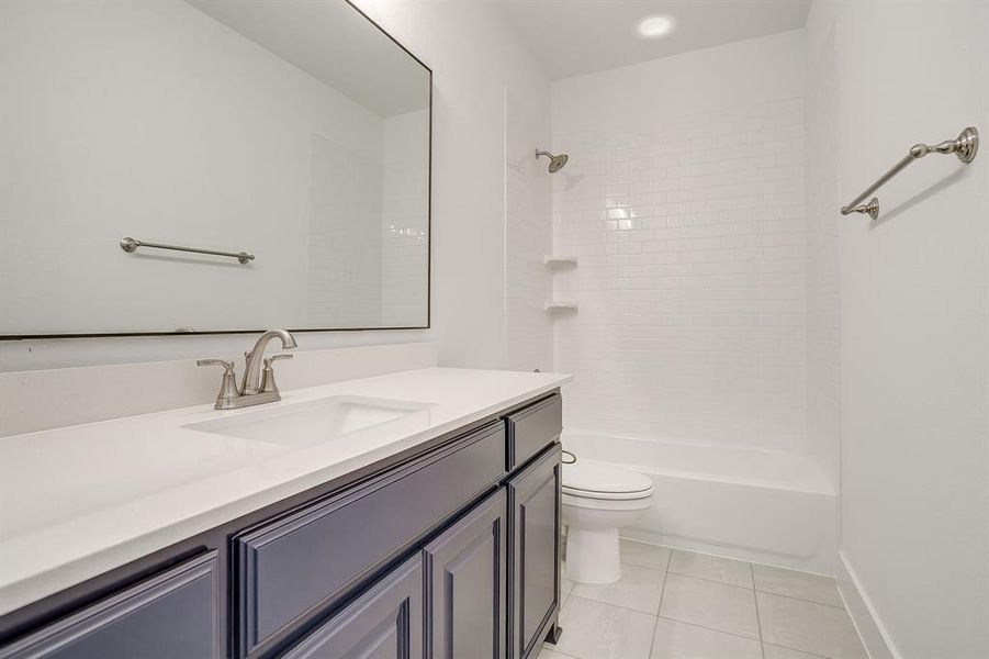 Bathroom with vanity, light tile patterned floors, and bathing tub / shower combination Bathroom with vanity, light tile patterned floors, and bathing tub / shower combination