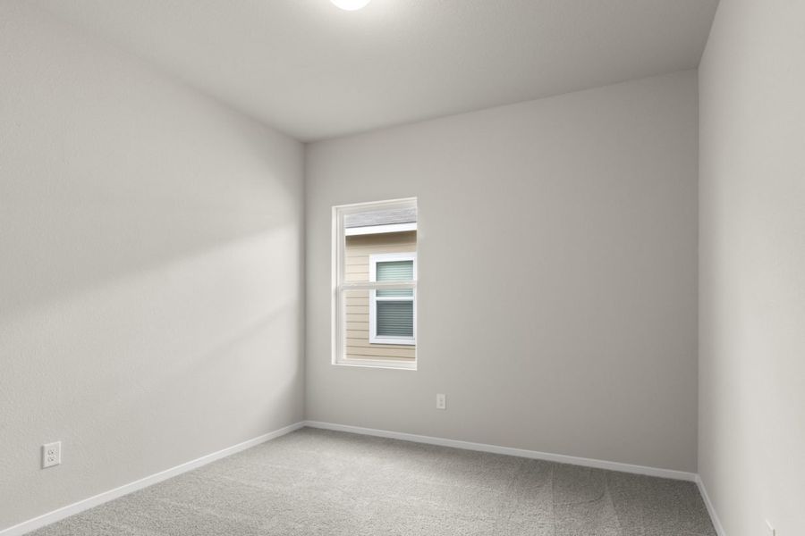 Image of bedroom with light grey carpet and painted walls with a window
