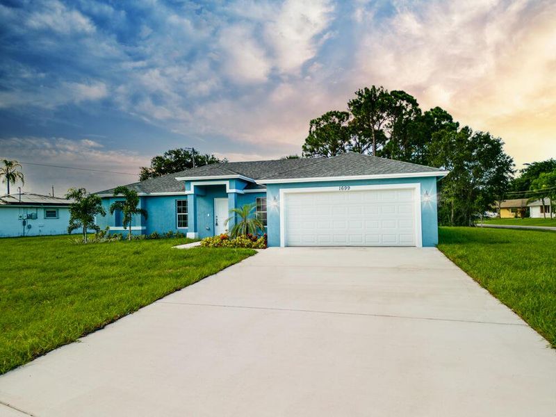 Front exterior of a new home in , Palm Bay, FL, highlighting curb appeal (Image 1).