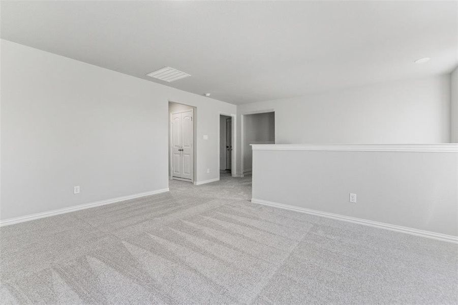 Spare room with light colored carpet and baseboards