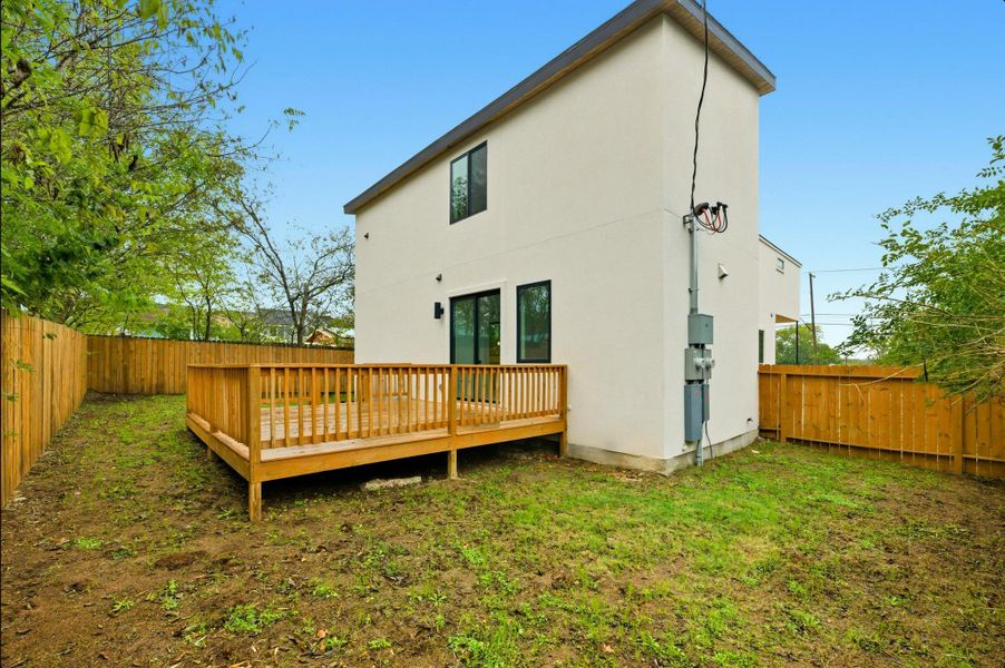 Rear view of property featuring a fenced backyard, a deck, and stucco siding Rear view of property featuring a fenced backyard, a deck, and stucco siding