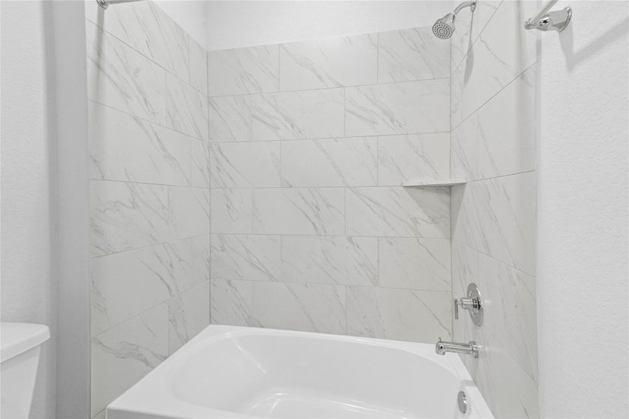 This additional view of the secondary bath highlights the tub/shower combination with tile surround.