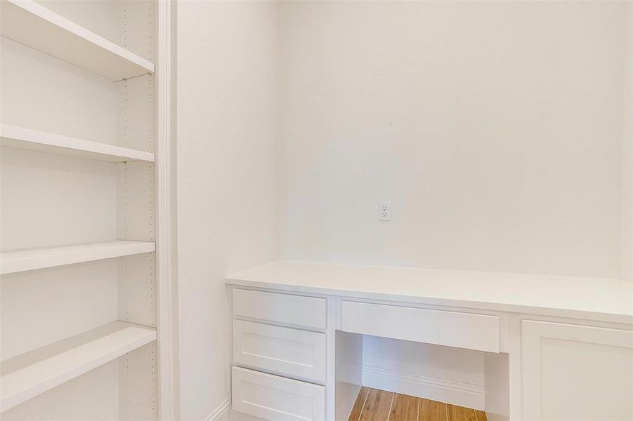 Walk in closet with wood-type flooring