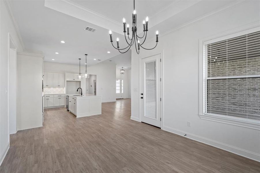 Kitchen with pendant lighting, a kitchen island with sink, light wood-style floors, recessed lighting, and white cabinets Kitchen with pendant lighting, a kitchen island with sink, light wood-style floors, recessed lighting, and white cabinets