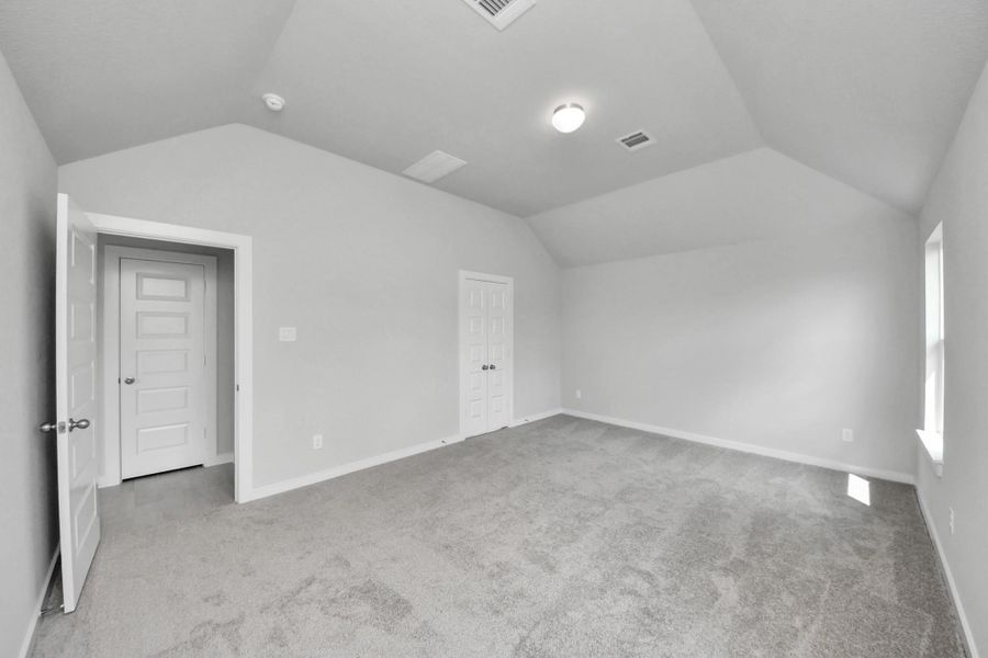 Escape and relax in the exquisite primary suite, a haven to unwind after a long day. The spacious room, located on first floor, boasts plush carpeting, soothing paint tones, high ceilings, and expansive windows adorned with privacy blinds. Sample photo of completed home with similar floor plan. Actual colors and selections may vary.