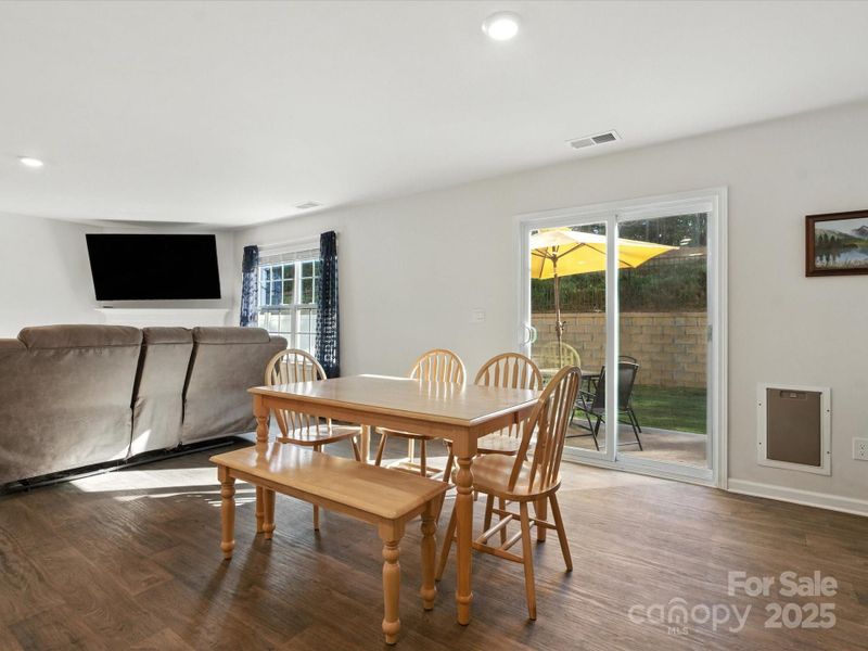 Bright dining space with sliding door access to covered patio and fenced backyard. Natural light and open floor plan create perfect setting for family meals and entertaining guests.