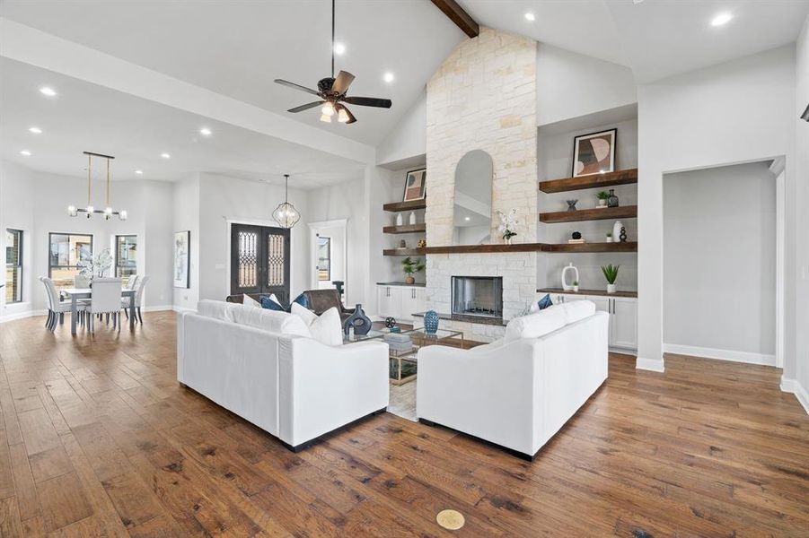 Living room with ceiling fan, dark hardwood / wood-style flooring, and high vaulted ceiling