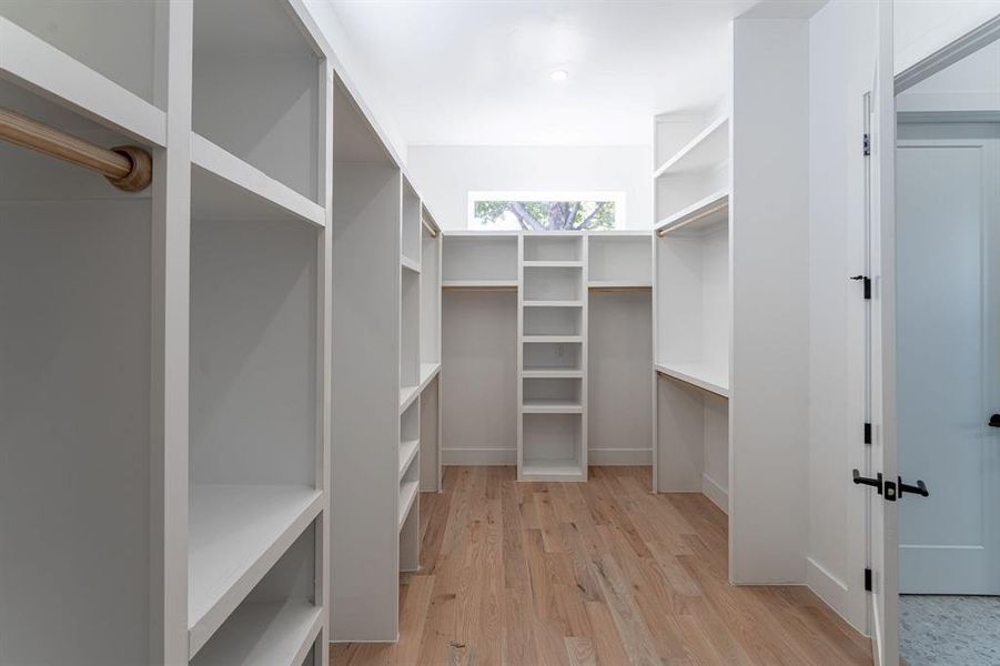 Spacious closet with light hardwood / wood-style floors