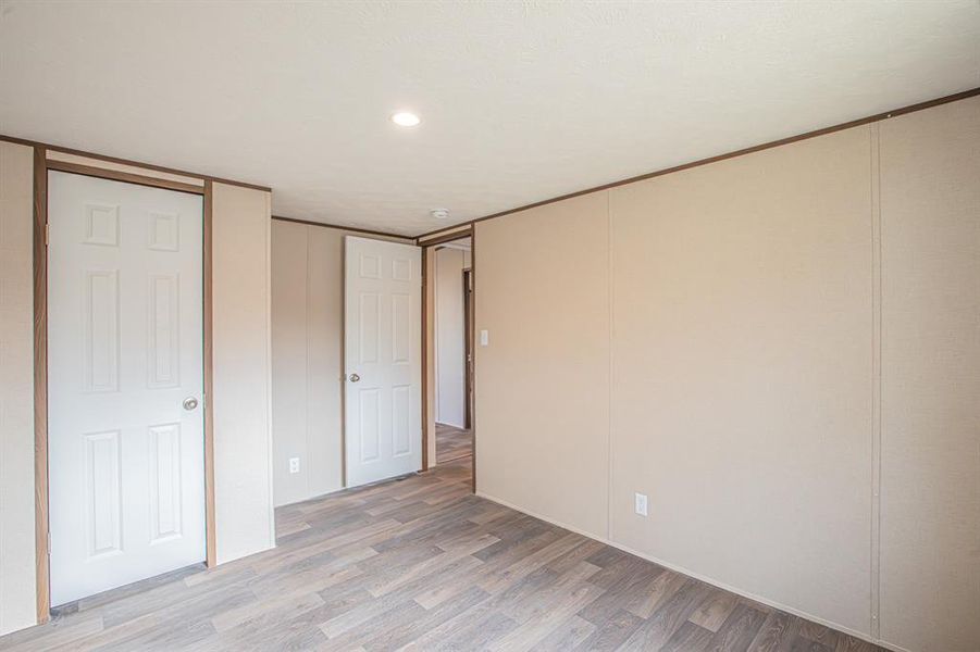 Unfurnished bedroom featuring light wood finished floors and recessed lighting Unfurnished bedroom featuring light wood finished floors and recessed lighting