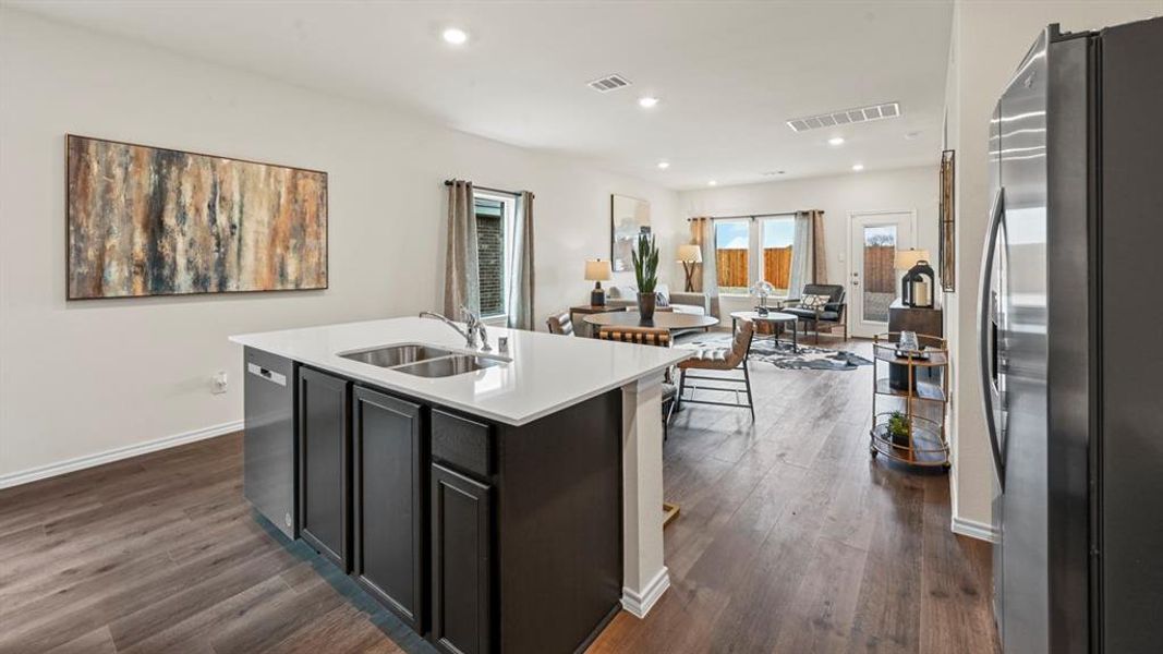 Kitchen featuring stainless steel appliances, open floor plan, recessed lighting, dark cabinetry, and an island with sink