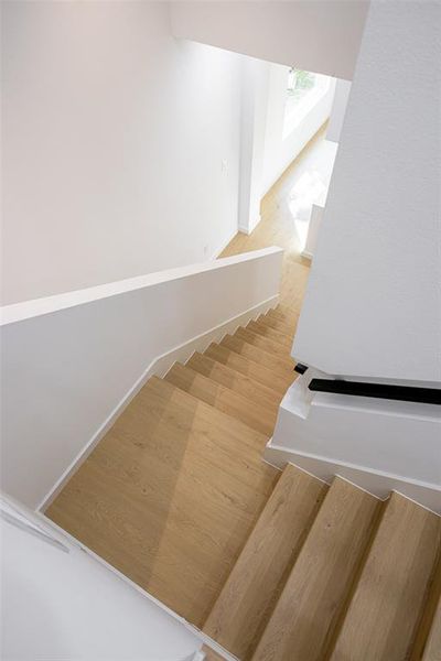 Stairway featuring wood finished floors