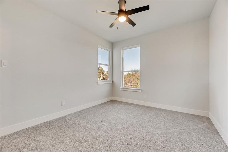 Spare room featuring light colored carpet and ceiling fan Spare room featuring light colored carpet and ceiling fan