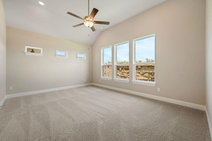 Unfurnished room featuring light carpet, lofted ceiling, and ceiling fan