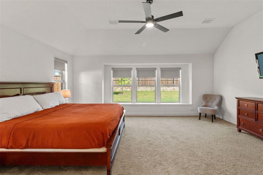 Bedroom featuring light carpet, a ceiling fan, and lofted ceiling