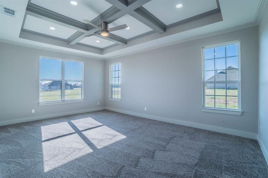 Empty room featuring coffered ceiling, ornamental molding, beam ceiling, carpet floors, and ceiling fan