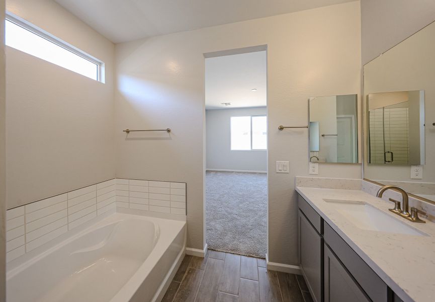 A bathroom with a tub sink and mirror. A bathroom with a tub sink and mirror.