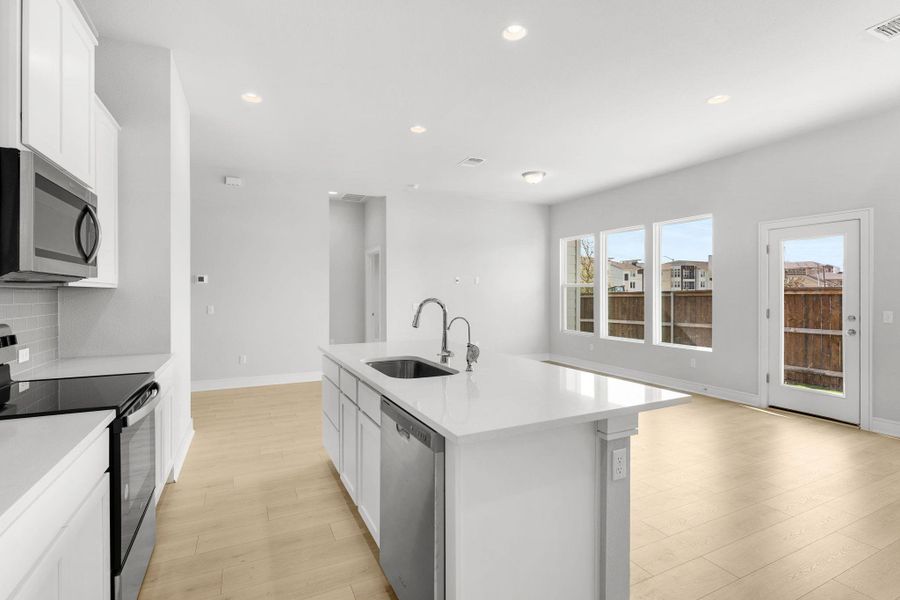 A well-appointed kitchen features a central island, recessed lighting, and durable wood flooring. A well-appointed kitchen features a central island, recessed lighting, and durable wood flooring.