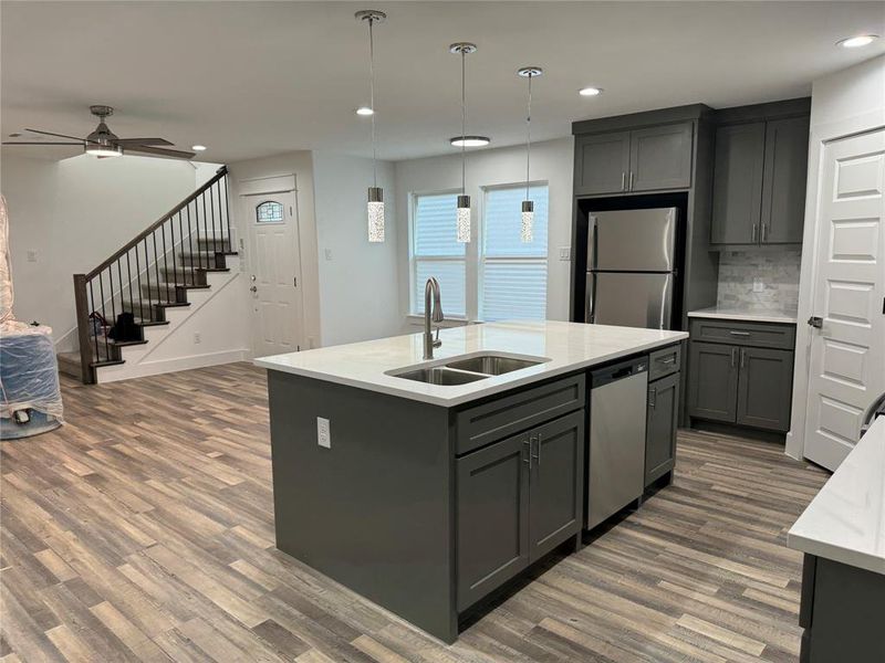 Kitchen with dark hardwood / wood-style flooring, sink, ceiling fan, appliances with stainless steel finishes, and gray cabinetry