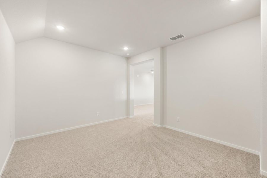 Empty room with white walls, beige carpet, recessed lighting, and an open doorway leading to a hallway. Empty room with white walls, beige carpet, recessed lighting, and an open doorway leading to a hallway.