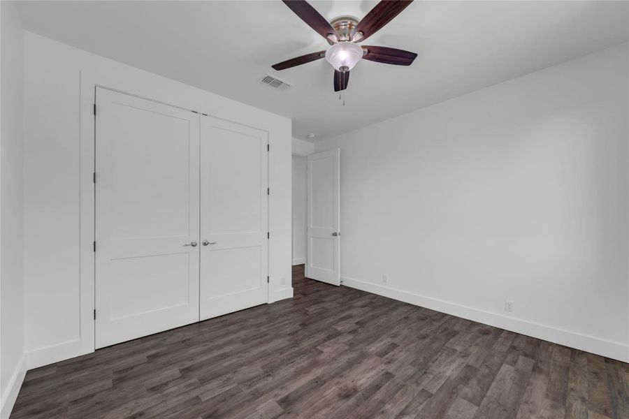 Guest Bedroom 2; Rich wood floors and clean white walls anchor this versatile secondary bedroom space.