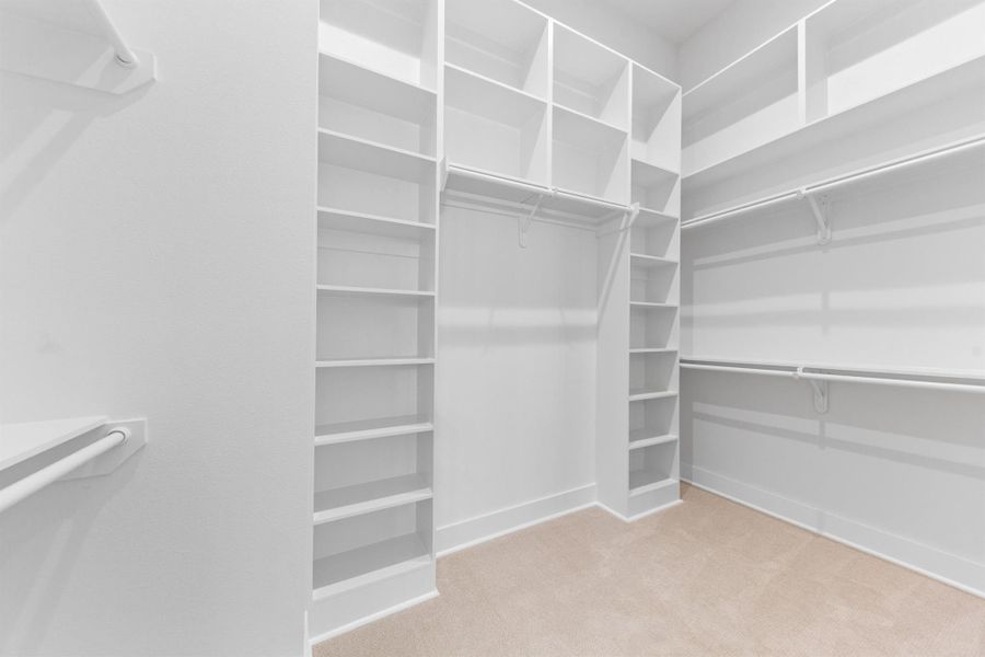 Spacious walk-in closet thoughtfully designed with abundant built-in shelving for optimal organization.