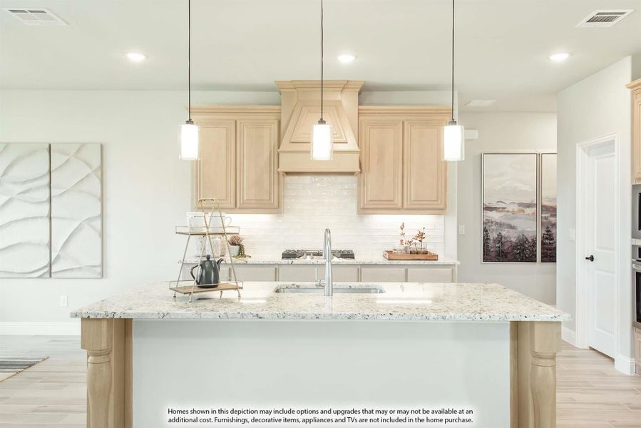 Kitchen with granite island, light wood cabinets, decorative range hood, and three pendant lights above sink Kitchen with granite island, light wood cabinets, decorative range hood, and three pendant lights above sink