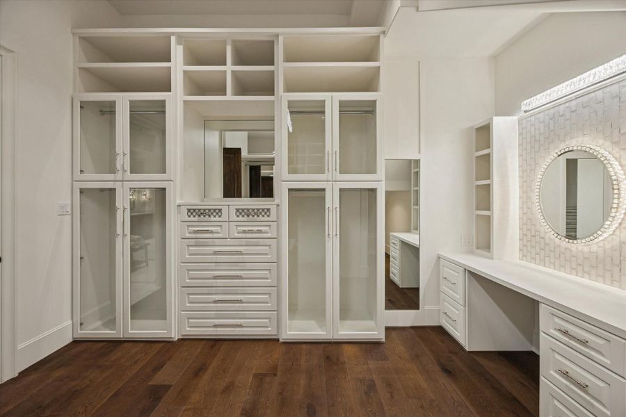 Spectacular boutique-inspired primary dressing room with custom built-ins, glass front cabinetry, display shelving, and abundant storage designed for the most discerning wardrobe. Spectacular boutique-inspired primary dressing room with custom built-ins, glass front cabinetry, display shelving, and abundant storage designed for the most discerning wardrobe.