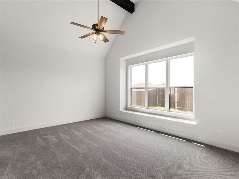 Unfurnished room featuring high vaulted ceiling, dark colored carpet, beamed ceiling, and a ceiling fan Unfurnished room featuring high vaulted ceiling, dark colored carpet, beamed ceiling, and a ceiling fan