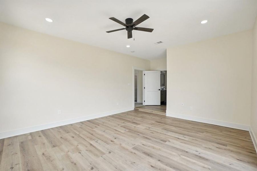 Empty room with light hardwood / wood-style floors and ceiling fan