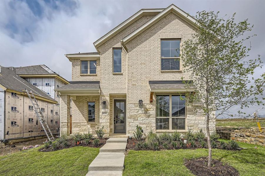 View of front of property featuring a front lawn, brick siding, stone siding, and a shingled roof View of front of property featuring a front lawn, brick siding, stone siding, and a shingled roof