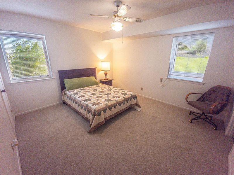 Carpeted bedroom with ceiling fan and baseboards Carpeted bedroom with ceiling fan and baseboards