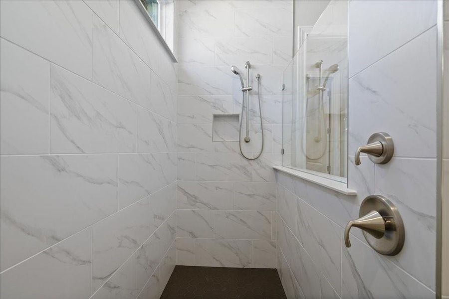 A glass partition and natural light add to the airiness of this en suite!